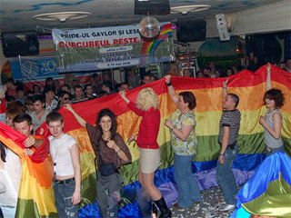 People dancing with the rainbow flag